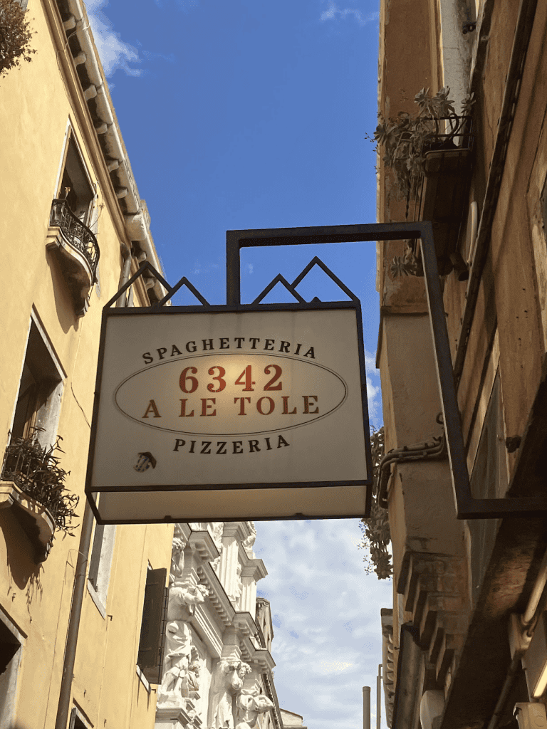 a restaurant sign in venice italy a le tole pizzeria