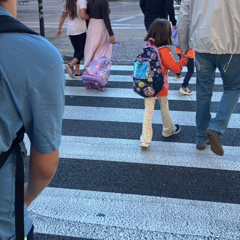 kids walking to school in spain, showing the different styles of backpacks available.